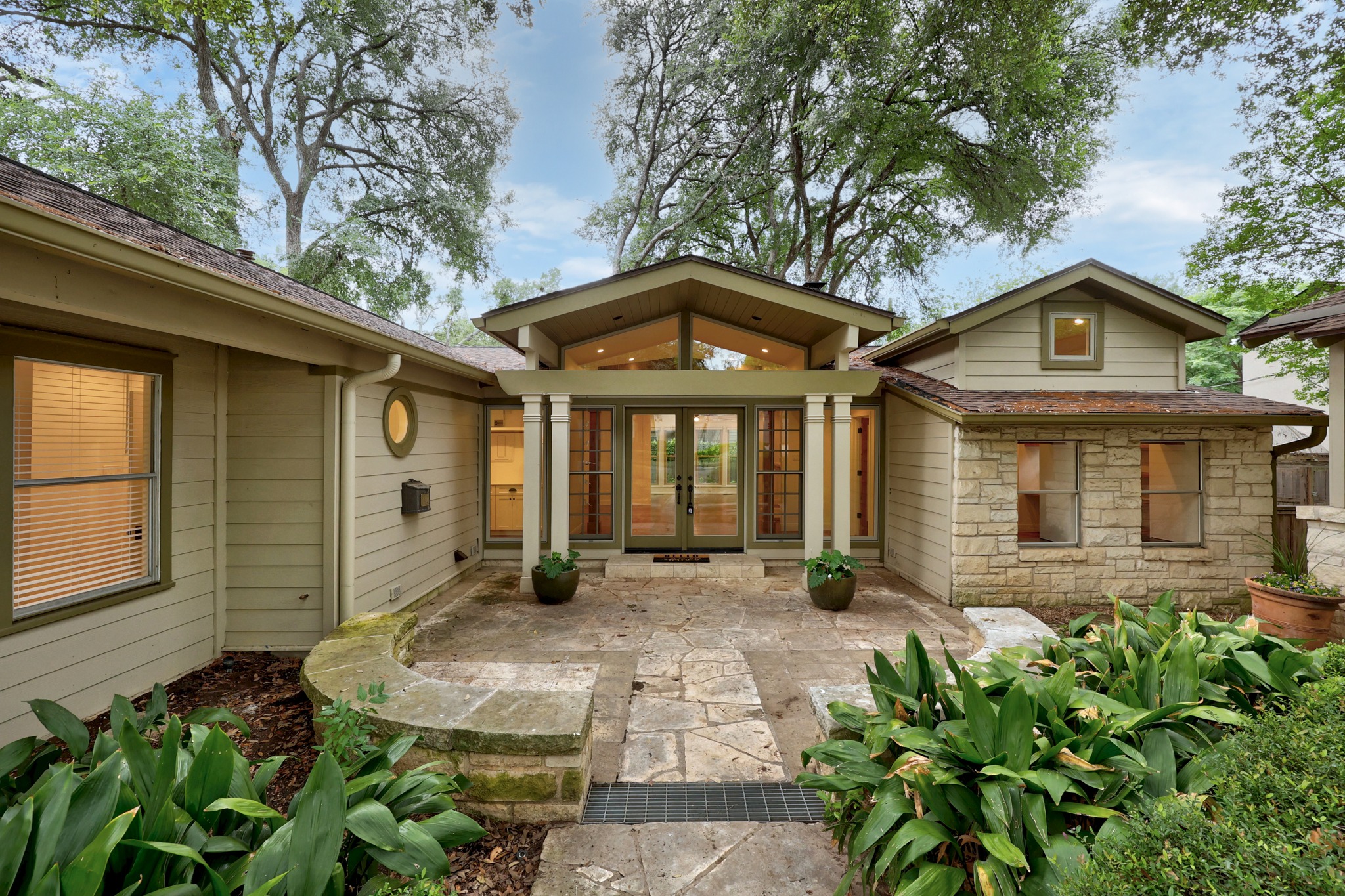 3205 Gilbert Street Austin, TX 78703 - Photo 3 of 35 Stone and siding exterior with a vaulted entry, double glass doors, and a stone patio