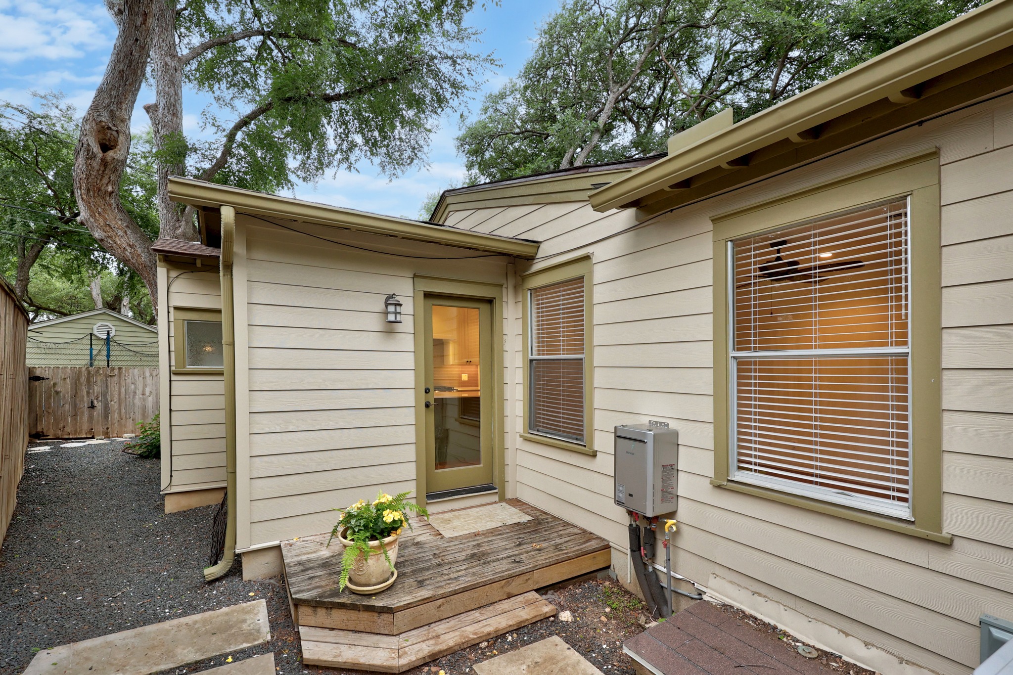 3205 Gilbert Street Austin, TX 78703 - Photo 35 of 35 Exterior featuring horizontal siding, multiple windows with blinds, a glass-paneled door, and a gravel pathway with stepping stones