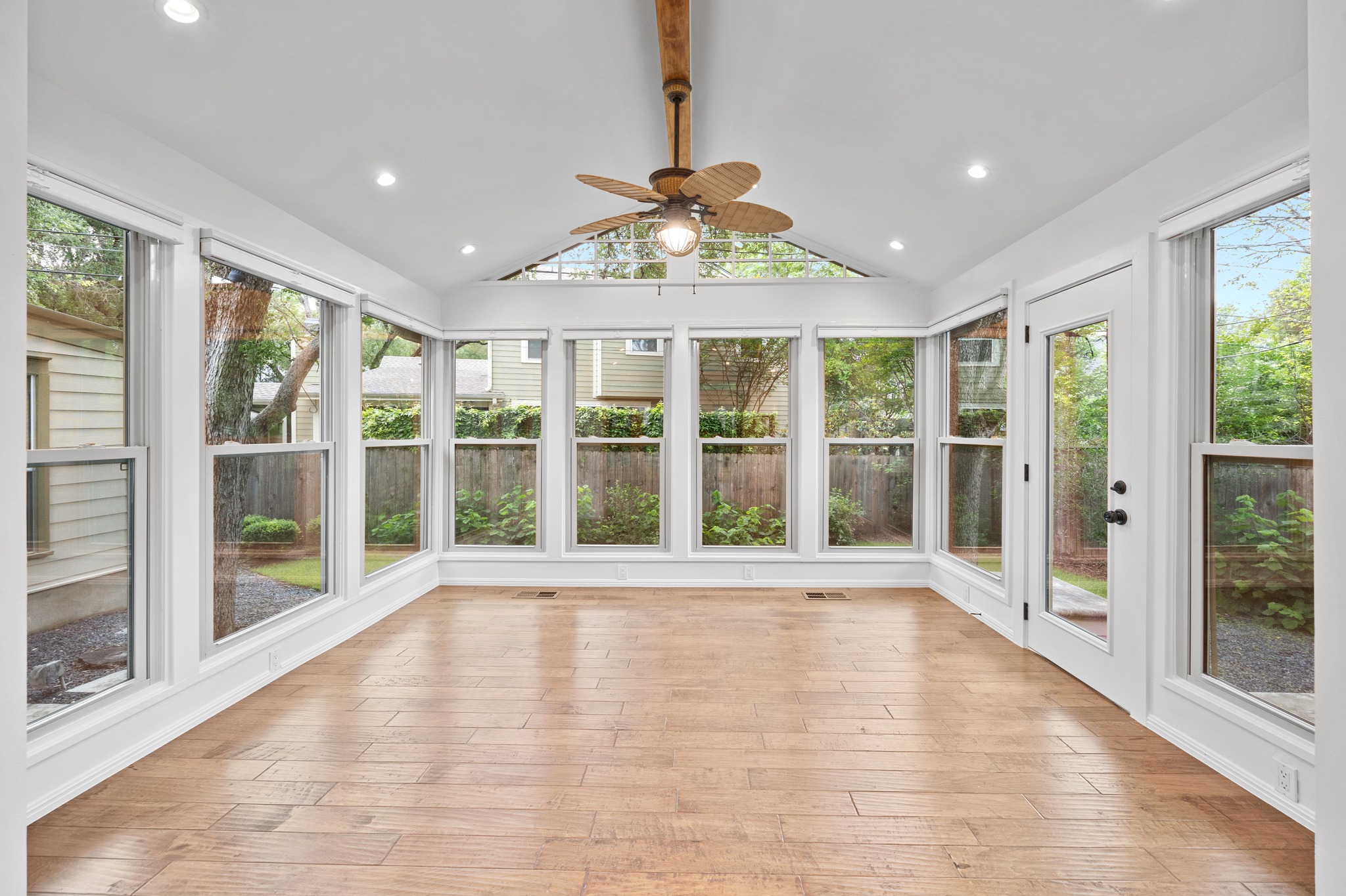 3205 Gilbert Street Austin, TX 78703 - Photo 5 of 35 Bright sunroom featuring abundant window walls, wood-finish flooring, a vaulted ceiling with exposed wood beam, recessed lighting, and a ceiling fan