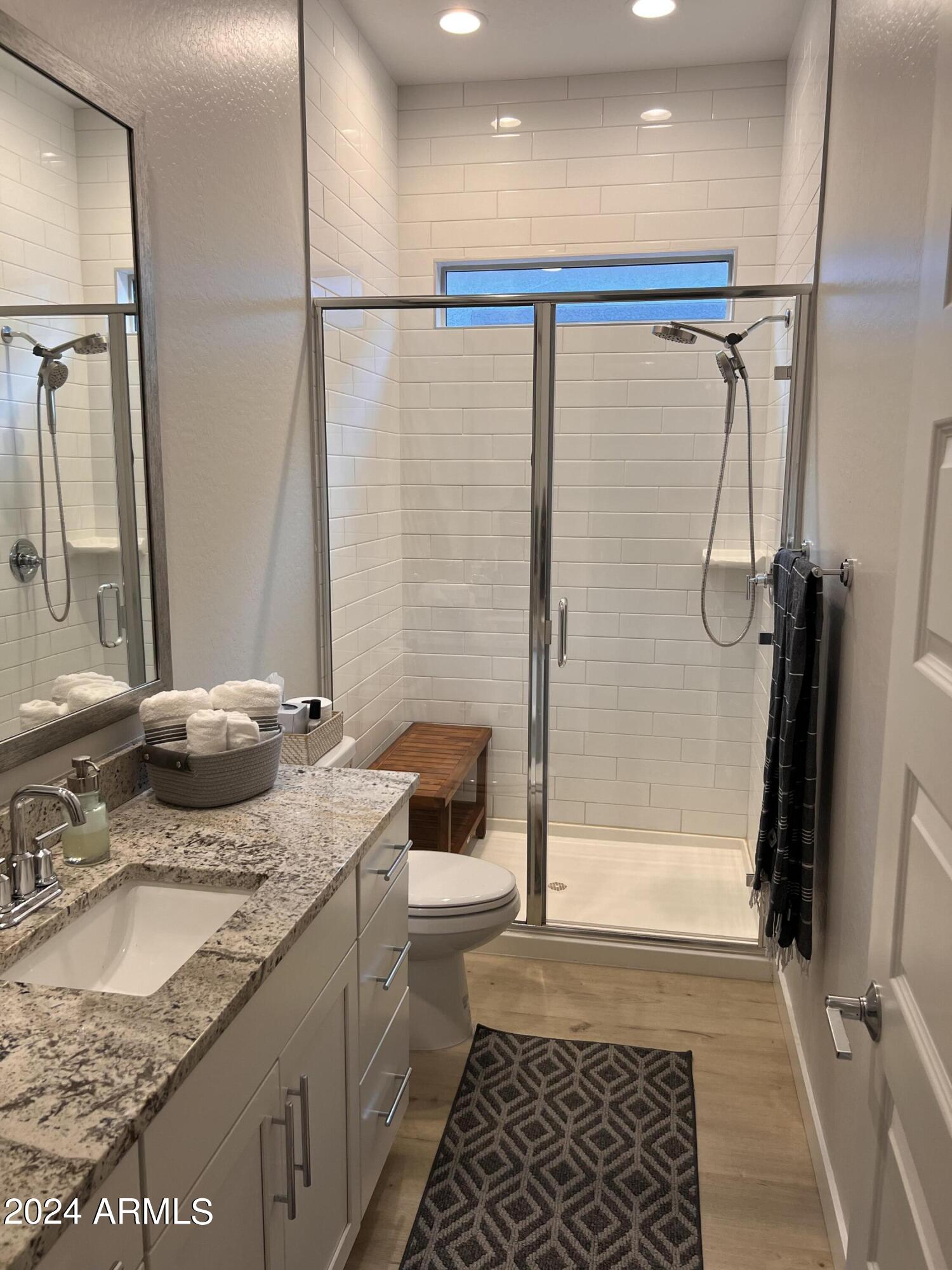9749 East Tahoe Avenue, Unit 2 Mesa, AZ 85212 - Photo 3 of 25 a bathroom with a granite countertop sink a toilet and shower