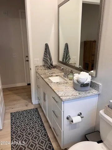a bathroom with a granite countertop sink and a mirror