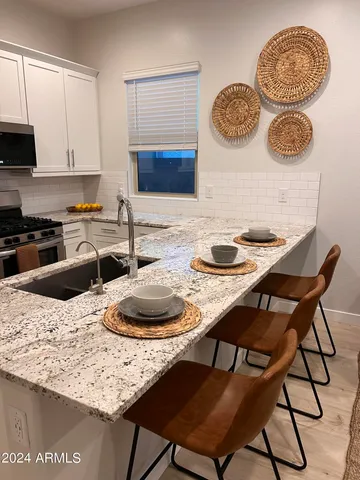 a kitchen with a table chairs and a stove top oven with wooden floor