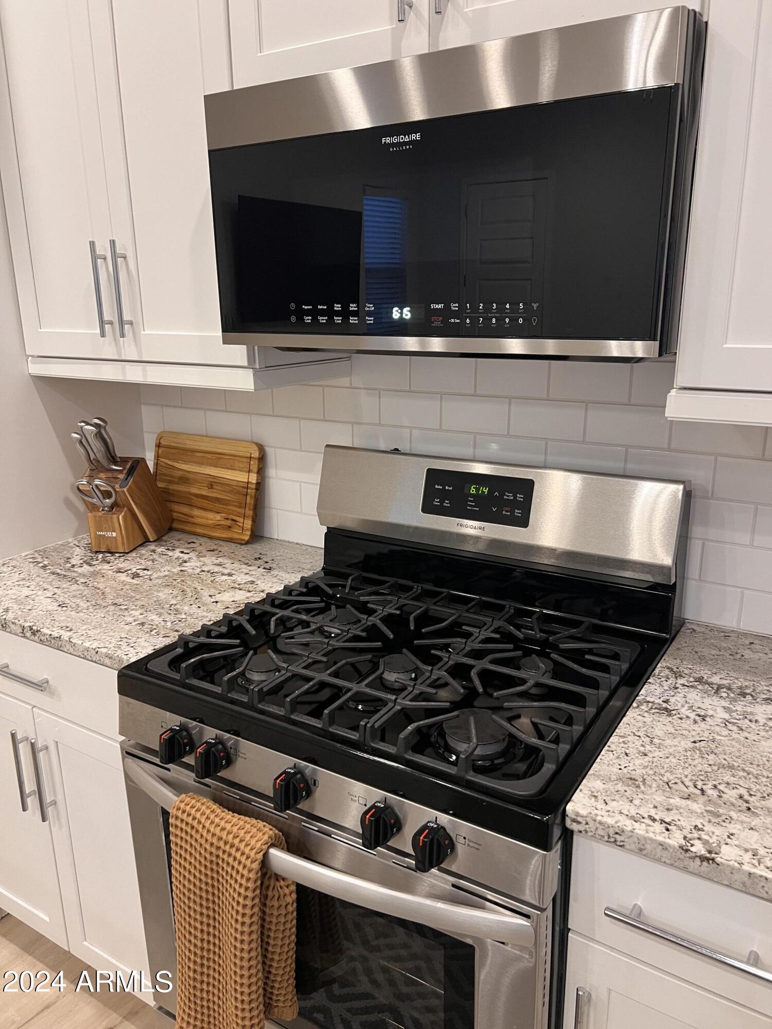 9749 East Tahoe Avenue, Unit 2 Mesa, AZ 85212 - Photo 10 of 25 a stove top oven sitting inside of a kitchen