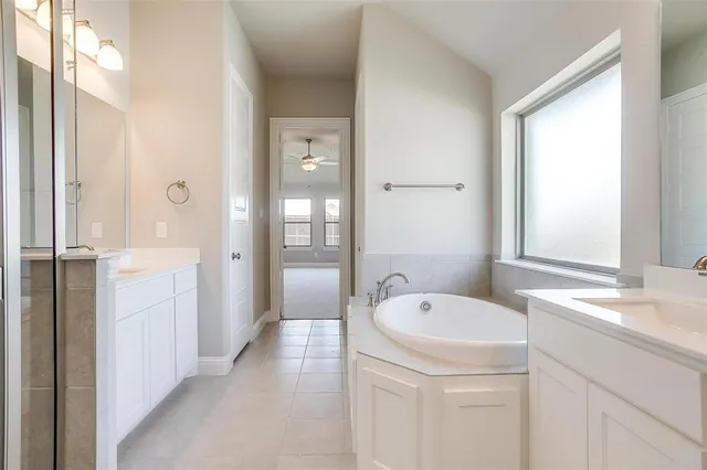 a large bathroom with a tub sink shower and mirror