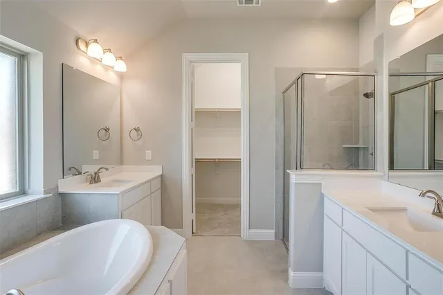 a bathroom with a tub sink shower and mirror