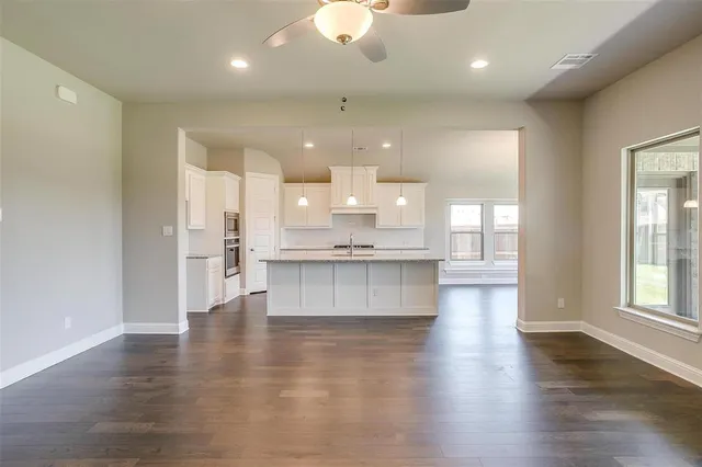 a view of kitchen with kitchen island and stainless steel appliances