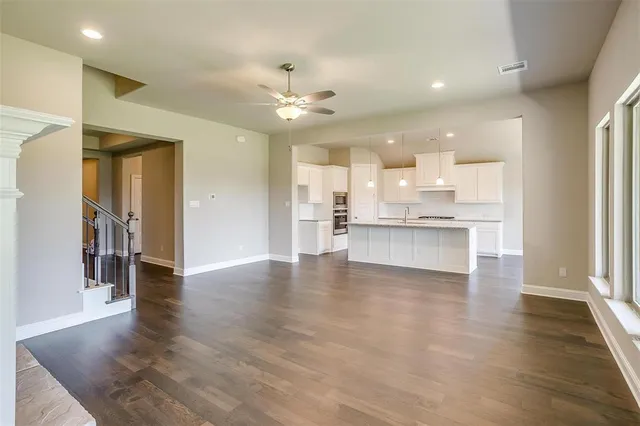 a view of large kitchen with a refrigerator and a stove top oven