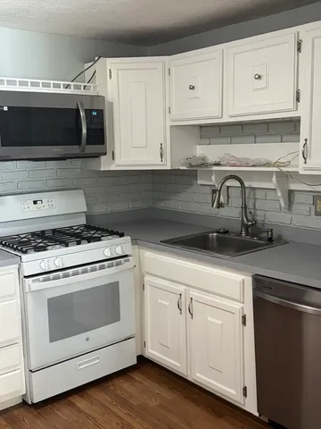 a kitchen with appliances a sink and cabinets