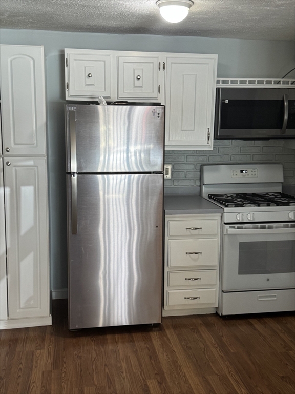 7 Karen Circle, Unit 2 Billerica, MA 01821 - Photo 2 of 11 a kitchen with white cabinets and stainless steel appliances