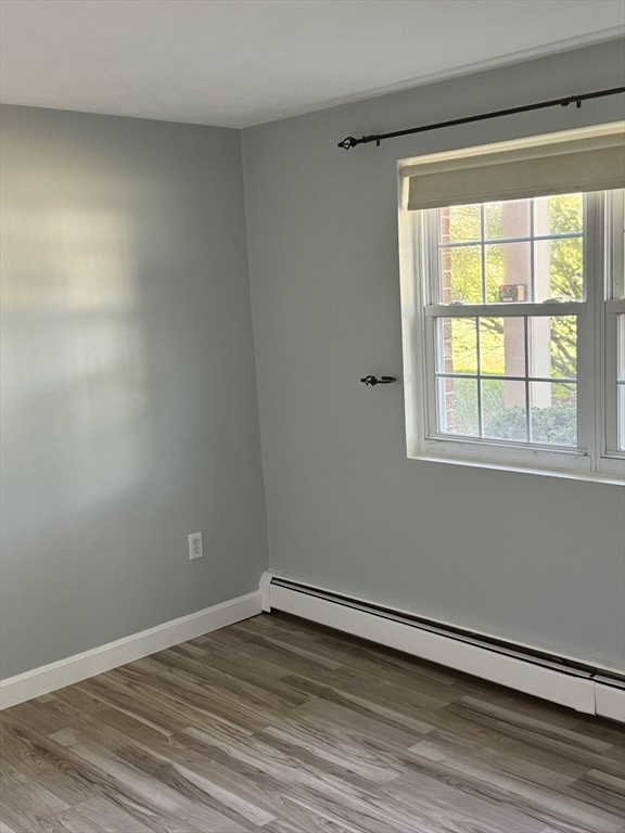 7 Karen Circle, Unit 2 Billerica, MA 01821 - Photo 6 of 11 a view of an empty room with wooden floor and a window