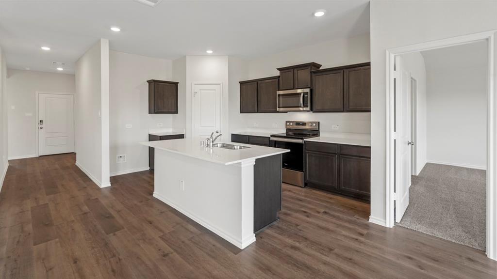 1969 Freeman Street Tyler, TX 75704 - Photo 4 of 30 Modern kitchen featuring a central island, dark wood-finish cabinetry, white countertops, stainless steel appliances, and wood-finish flooring