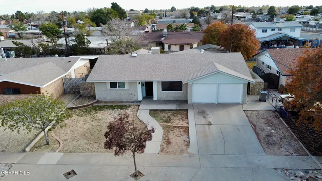 a aerial view of a house with a yard and large tree
