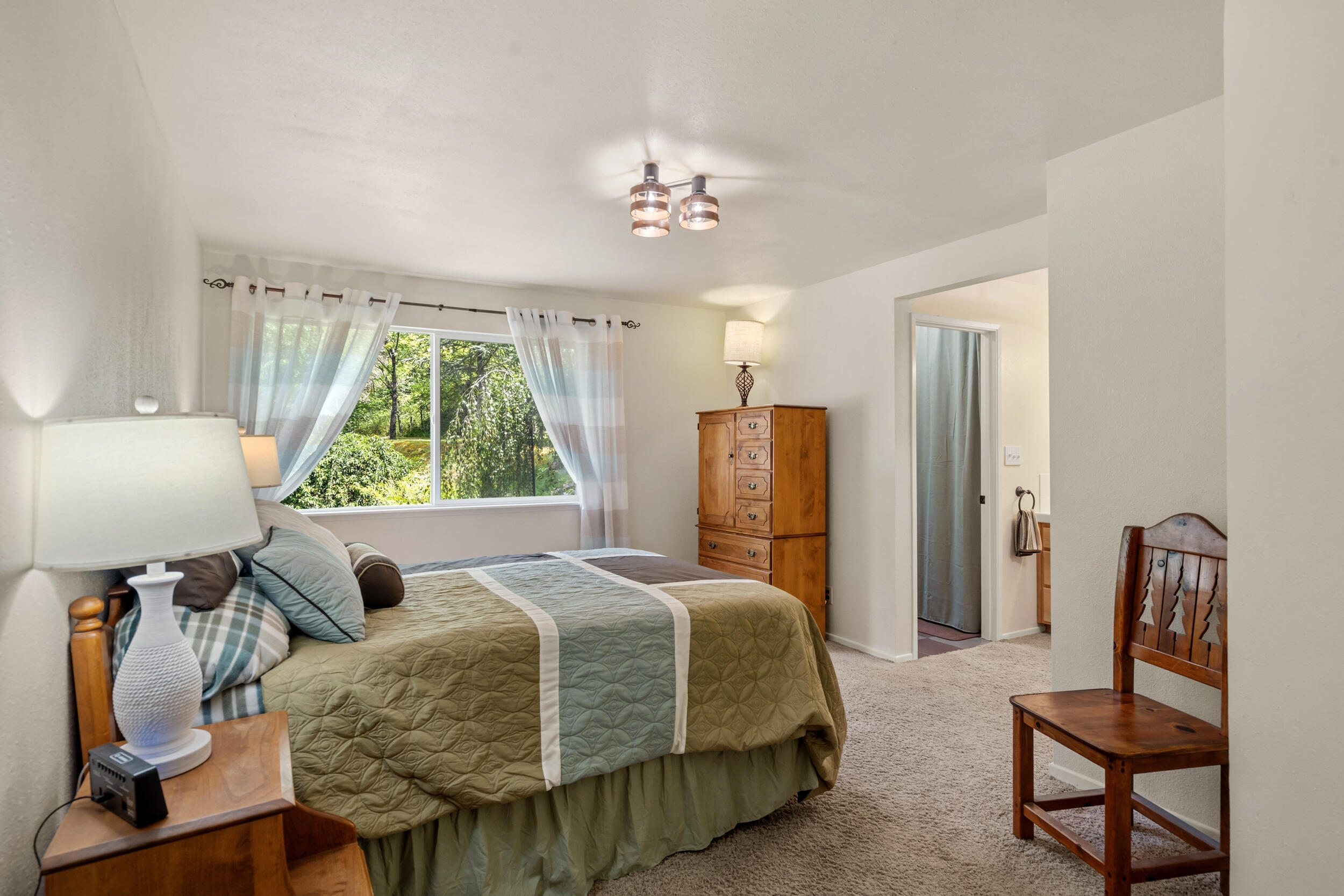3268 Humbug Creek Road Jacksonville, OR 97530 - Photo 18 of 36 a bedroom with a bed and a chandelier