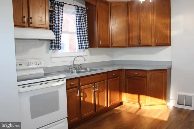 a kitchen with stainless steel appliances granite countertop wooden cabinets a sink and a stove