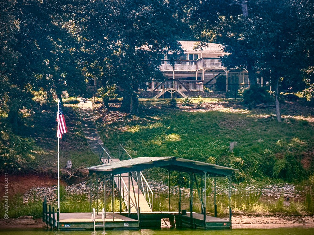 4518 Cove Trail Anderson, SC 29621 - Photo 12 of 49 A private boat dock sits at the water's edge below a wooded hillside setting.
