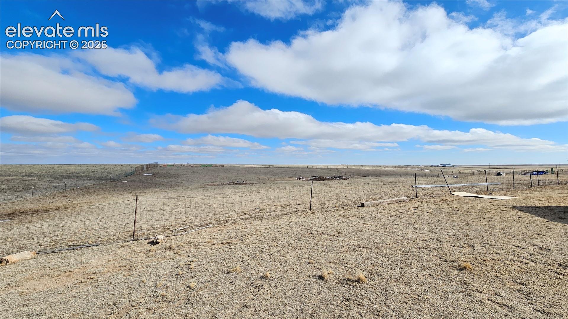 3835 Sengbeil Road Yoder, CO 80864 - Photo 7 of 48 Expansive open terrain featuring natural vegetation, a wire fence line, and distant structures under a broad sky
