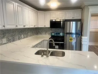 a kitchen with stainless steel appliances a refrigerator a sink a stove a microwave and cabinets