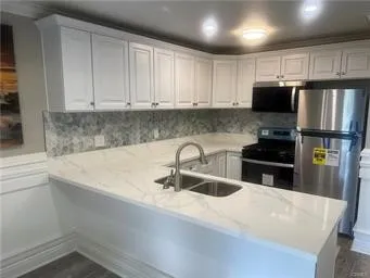 a kitchen with kitchen island a sink stainless steel appliances and cabinets