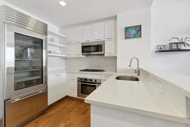 a kitchen with stainless steel appliances a stove microwave and sink