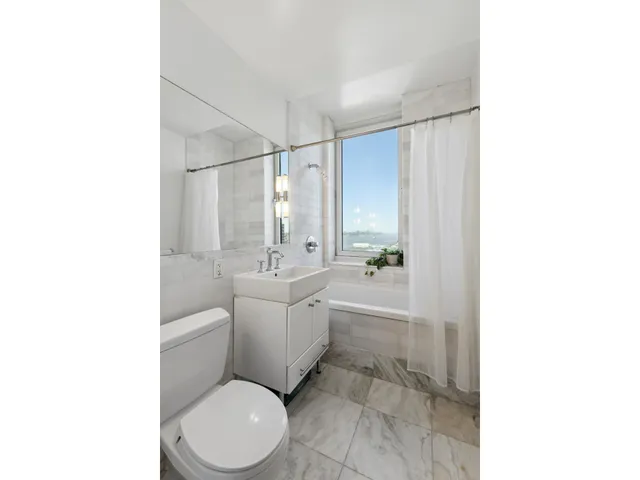 a bathroom with a toilet a sink and mirror