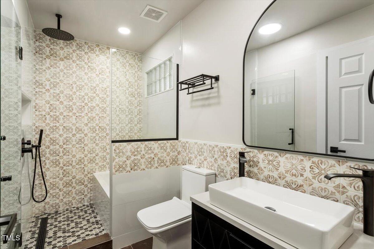 7414 Brandon Allen Avenue Raleigh, NC 27613 - Photo 35 of 57 a bathroom with a sink toilet and shower