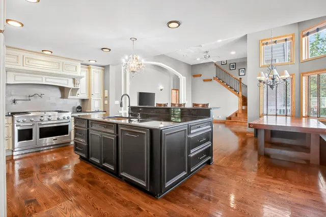 a kitchen with stainless steel appliances granite countertop a stove and a white cabinets