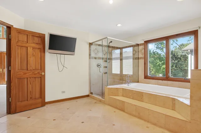 a spacious bedroom with a bed and a flat screen tv