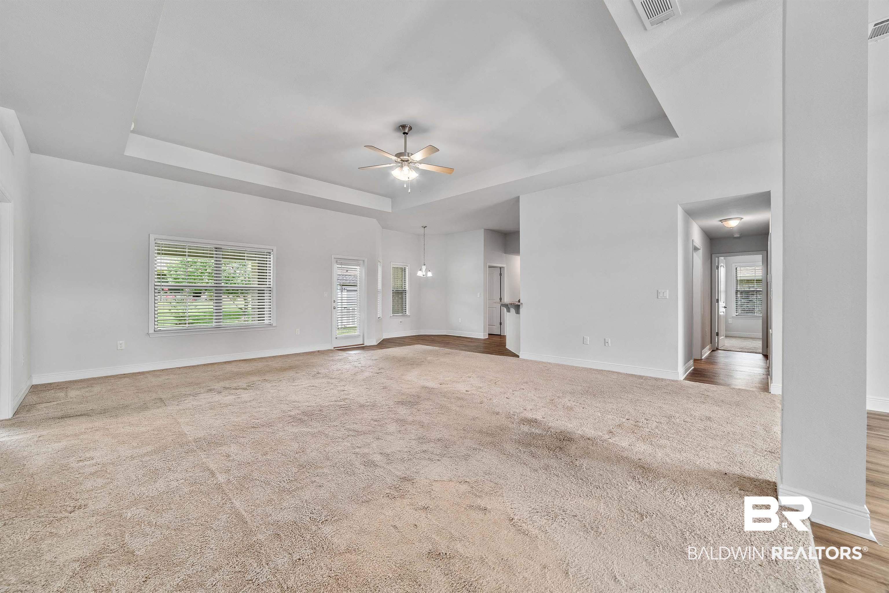 13155 Wishbone Court Foley, AL 36535 - Photo 5 of 39 Unfurnished living room featuring light carpet, a raised ceiling, and ceiling fan