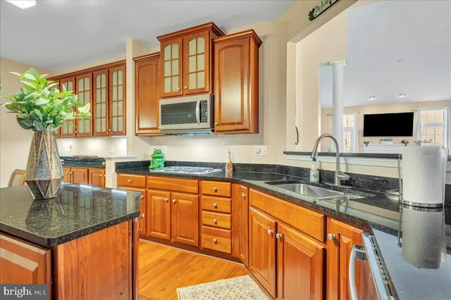 a kitchen with stainless steel appliances granite countertop a sink stove and microwave