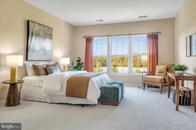 a bedroom with a bed and large windows