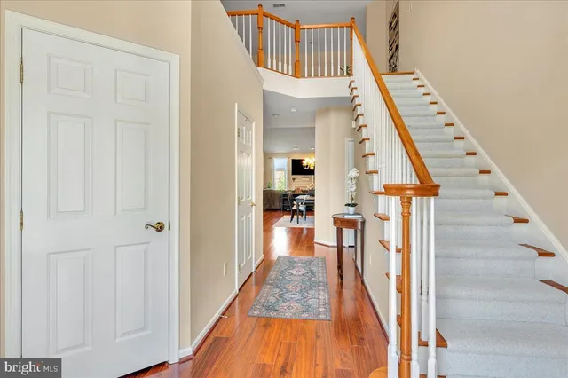 a view of a hallway with wooden floor and staircase