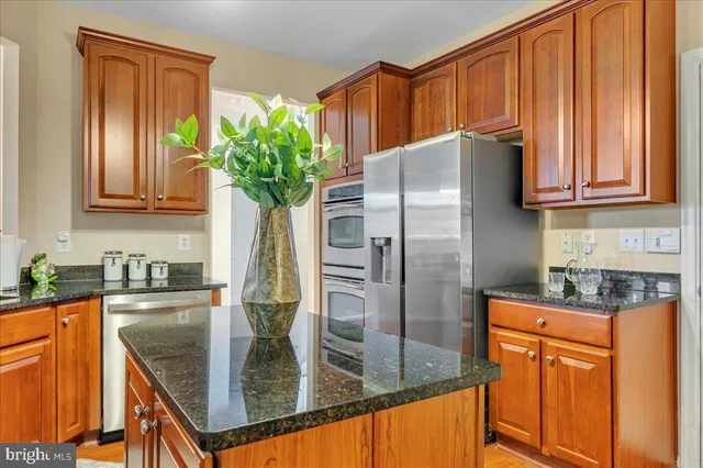 a kitchen with stainless steel appliances granite countertop a refrigerator a stove and cabinets