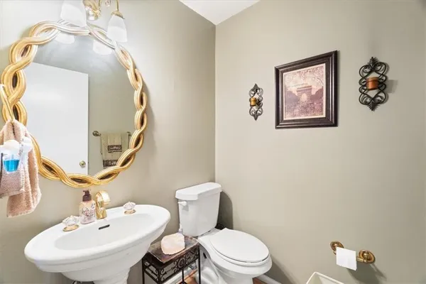 a bathroom with a toilet sink and mirror