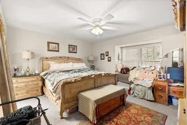 a spacious bedroom with a bed a couch and a chandelier