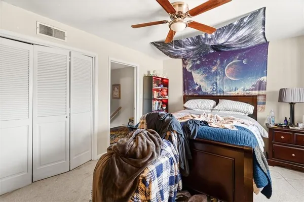 a bedroom with a bed and dresser with the view of bathroom