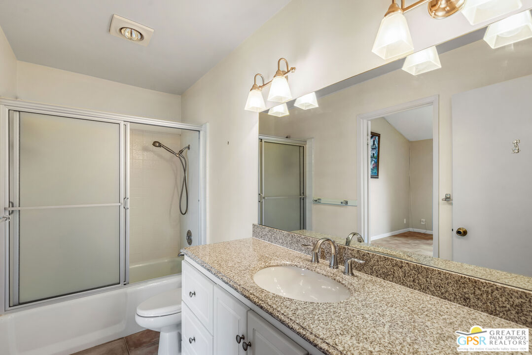 6090 East Driver Road Palm Springs, CA 92264 - Photo 23 of 29 a bathroom with a granite countertop sink toilet and shower