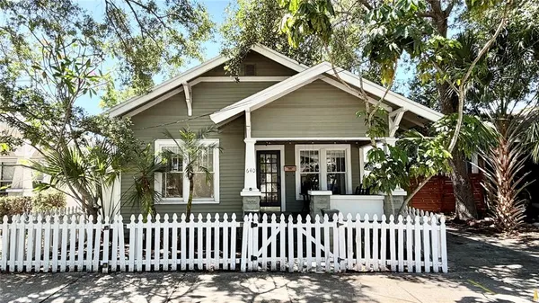 a view of a house with a small yard and wooden fence