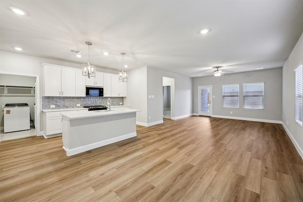 1721 Arches Road Anna, TX 75409 - Photo 7 of 39 a kitchen with a refrigerator and white cabinets with wooden floor
