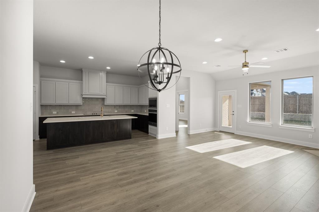 478 Red Maple Road Waxahachie, TX 75165 - Photo 12 of 27 a large kitchen with stainless steel appliances granite countertop a stove a sink and a large window