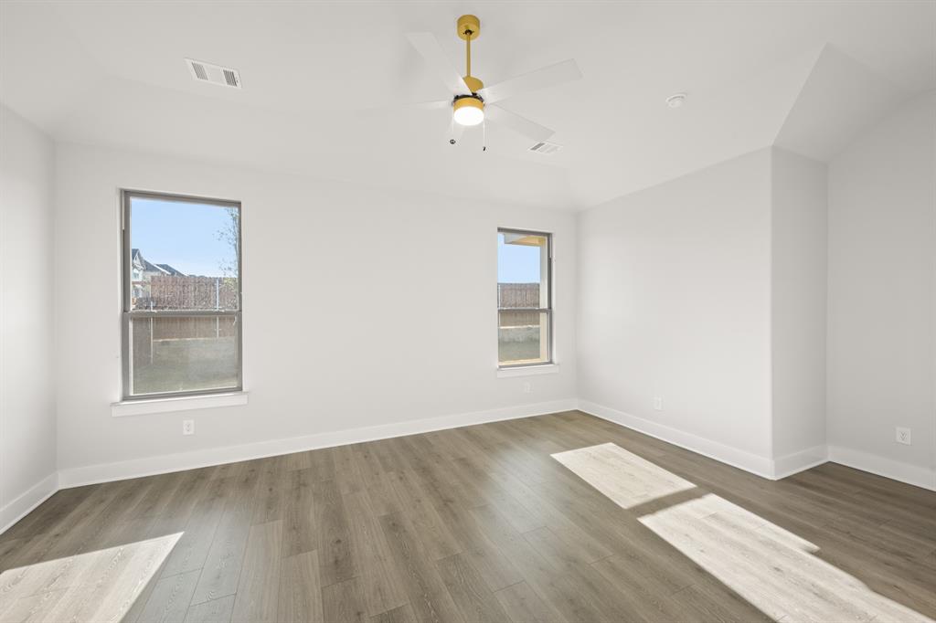 478 Red Maple Road Waxahachie, TX 75165 - Photo 19 of 27 an empty room with wooden floor and windows