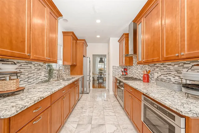 a kitchen with stainless steel appliances granite countertop a sink a stove and a refrigerator