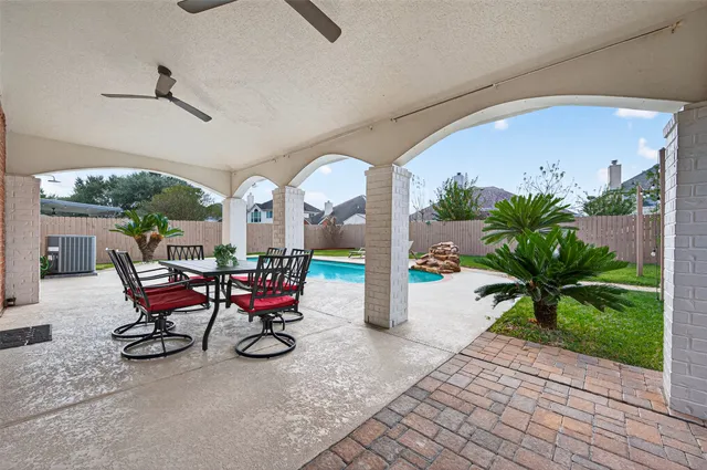a view of a chairs and table in patio next to a yard