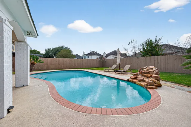 a view of house with backyard and swimming pool