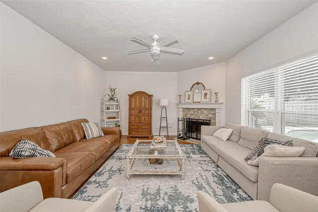 a living room with furniture a fireplace and a large window