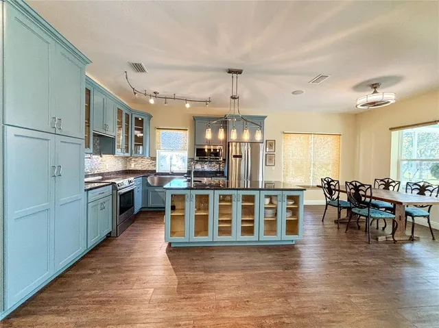 a kitchen with sink refrigerator and large window