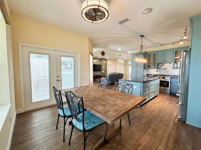 a kitchen with stainless steel appliances granite countertop a sink a stove and a refrigerator