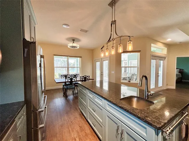 a kitchen with stainless steel appliances wooden floor dining table and chairs