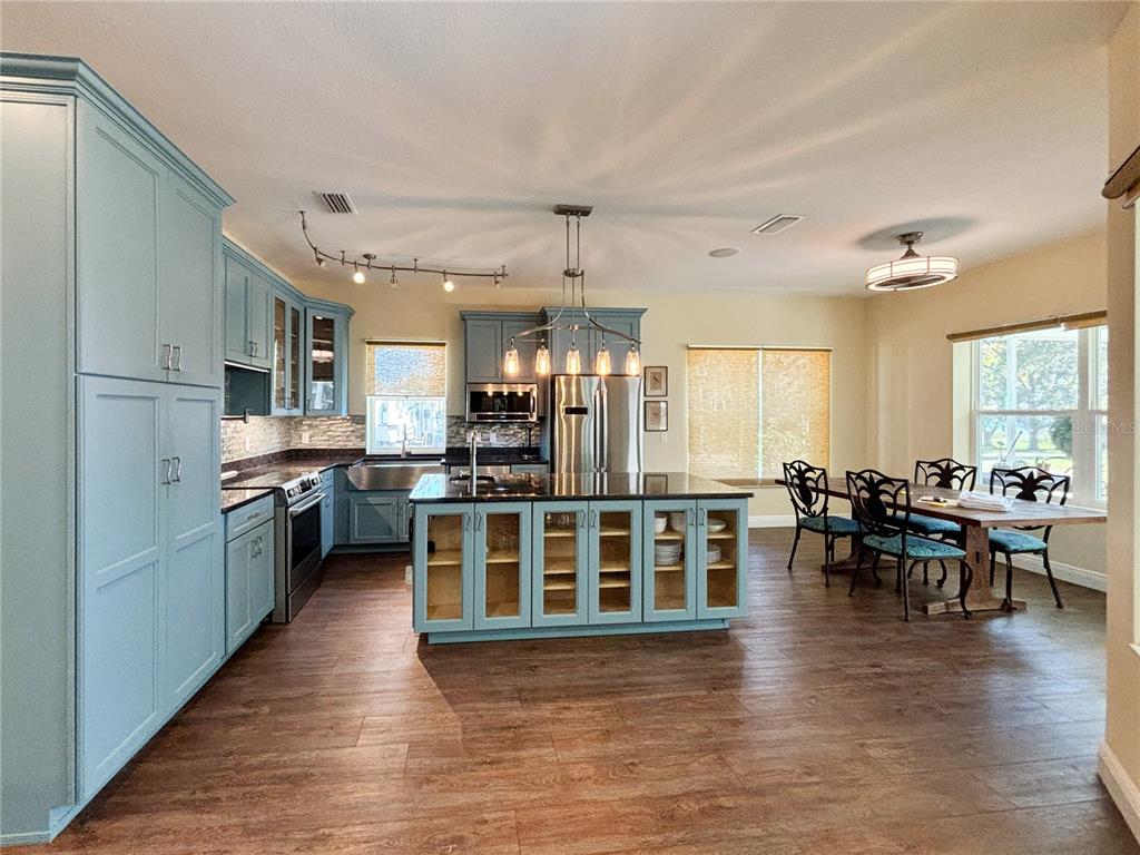 19151 Southeast 135th Court Dunnellon, FL 34431 - Photo 24 of 65 a kitchen with stainless steel appliances wooden floor dining table and chairs