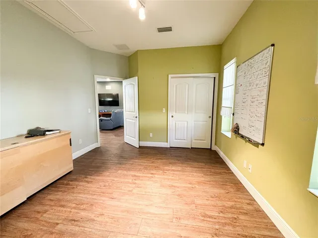 a view of a hallway with wooden floor and a living room