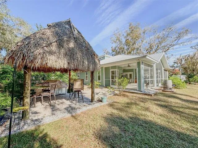 a view of a house with backyard and sitting area